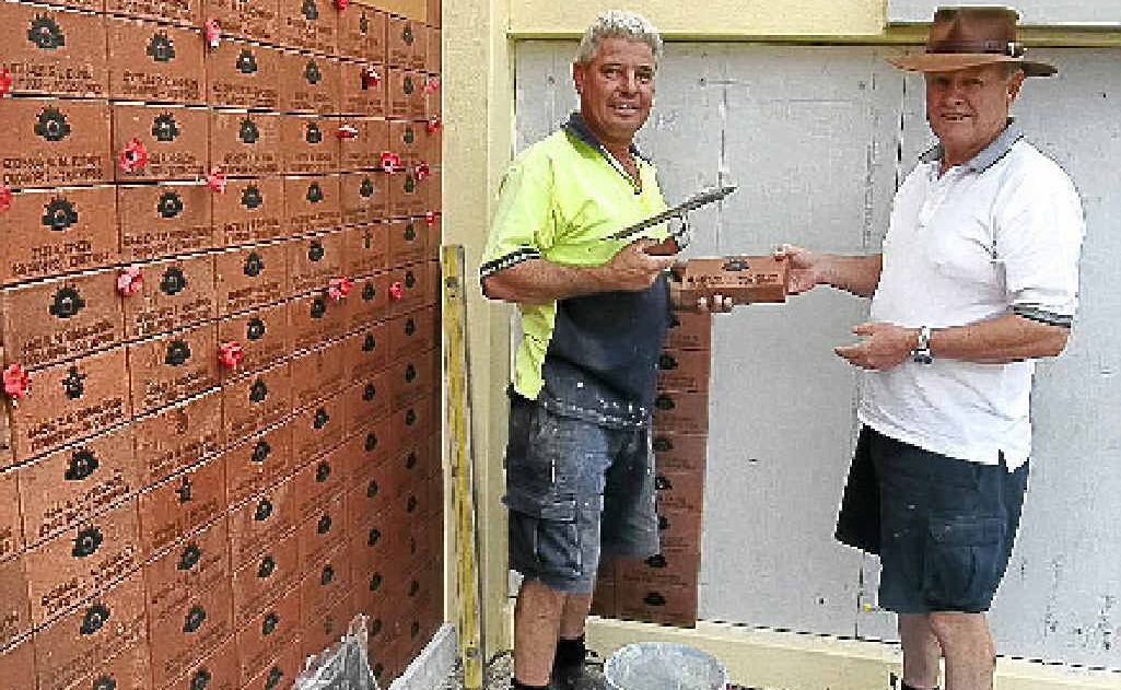 Wayne Sellick and Rod Strahan build the wall. Wayne Sellick and Rod Strahan build the wall.